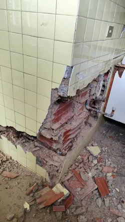 Kitchen wall damage connecting to the main bathroom view 1