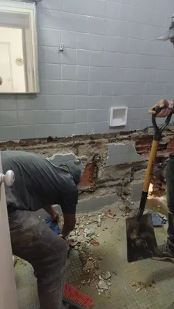 Plumbers working in the bathroom to cap the damaged pipes